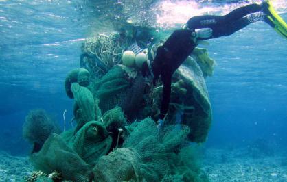 A marine debris removal diver conducts an assessment of a derelict net conglomerate at Midway Atoll, Northwestern Hawaiian Islands | Credit: JIMAR/NOAA PIFSC​