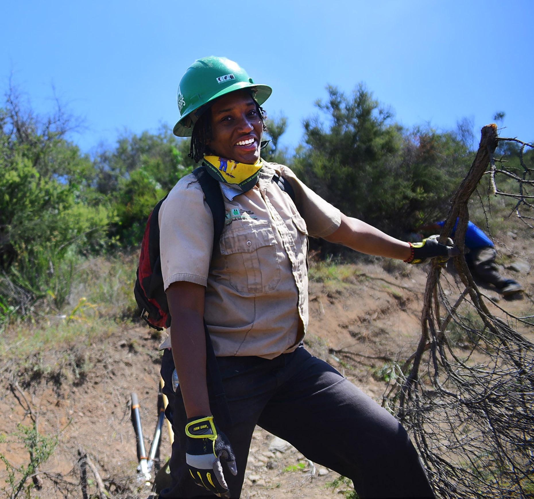 Youth corps member removing fire fuel